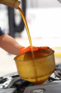 Oil being poured into a vehicle.