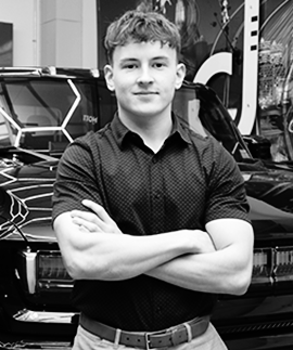 A salesperson stands with his arms crossed in front of a Hummer EV.